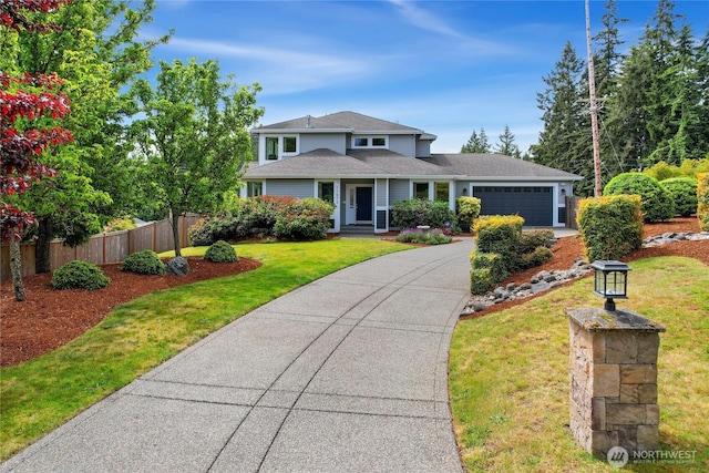 traditional-style home featuring a garage, driveway, and a shingled roof