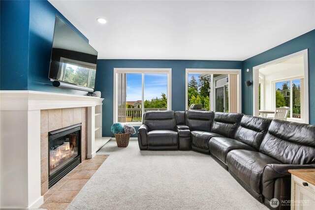living area with a tile fireplace, light colored carpet, and recessed lighting