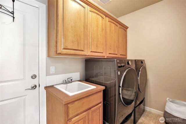 laundry area featuring cabinet space, independent washer and dryer, light tile patterned floors, and baseboards
