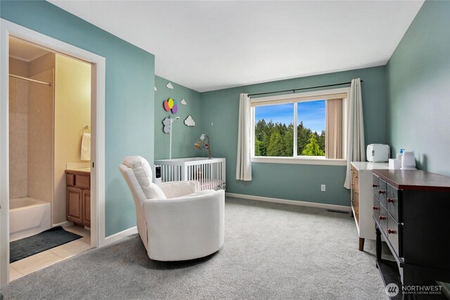 carpeted bedroom featuring baseboards and ensuite bath