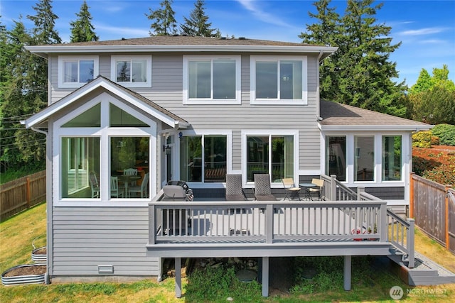 back of property with a wooden deck, fence, a sunroom, and a shingled roof