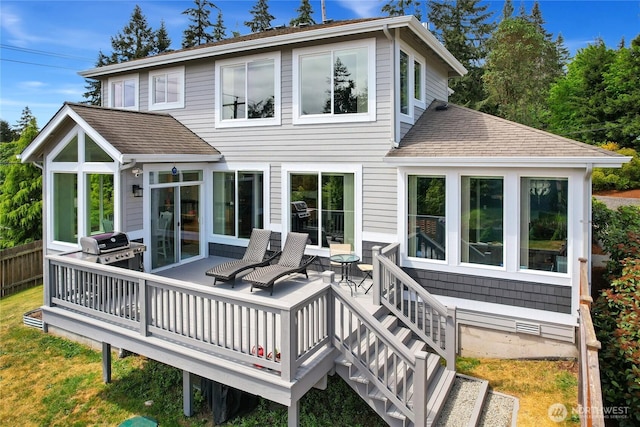 rear view of house with roof with shingles and a deck