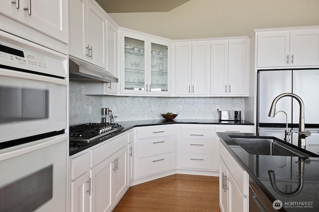 4638 Tanner View Dr, Clinton, WA 98236 - kitchen with under cabinet range hood, stainless steel gas stovetop, white double oven, a sink, and white cabinets