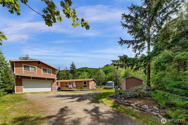 846 Deep Valley Dr, Maple Falls, WA 98266 - view of front facade featuring driveway, a garage, and a storage shed