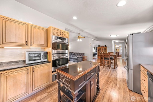 846 Deep Valley Dr, Maple Falls, WA 98266 - kitchen with stainless steel appliances, dark countertops, a ceiling fan, light wood-style floors, and tasteful backsplash
