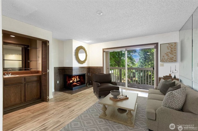 12840 SE 40th Ct Unit B2, Bellevue, WA 98006 - living room featuring light wood-style floors, a brick fireplace, and a textured ceiling