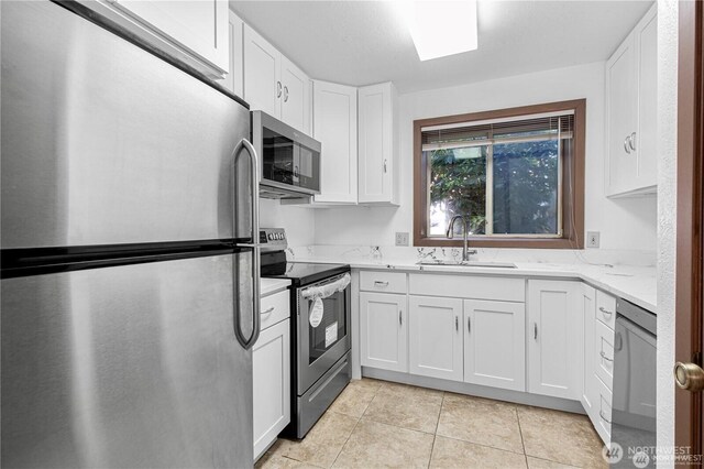 12840 SE 40th Ct Unit B2, Bellevue, WA 98006 - kitchen with stainless steel appliances, a sink, white cabinets, light tile patterned flooring, and light stone countertops