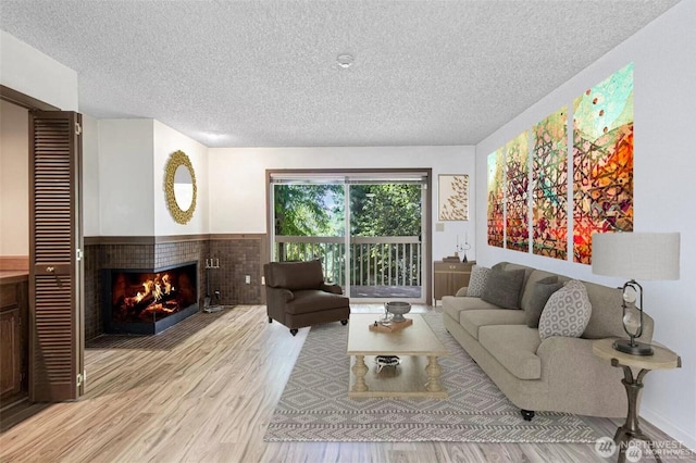12840 SE 40th Ct Unit B2, Bellevue, WA 98006 - living room with a textured ceiling, light wood finished floors, and a multi sided fireplace