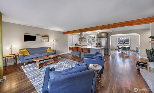 321 Park Pl, Lynden, WA 98264 - living area with a chandelier, arched walkways, baseboards, dark wood-style flooring, and beam ceiling
