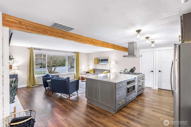 321 Park Pl, Lynden, WA 98264 - kitchen with wall chimney range hood, stainless steel appliances, gray cabinetry, open floor plan, and dark wood-style floors