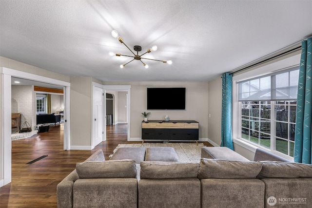 321 Park Pl, Lynden, WA 98264 - living area featuring a chandelier, a textured ceiling, baseboards, and dark wood-type flooring