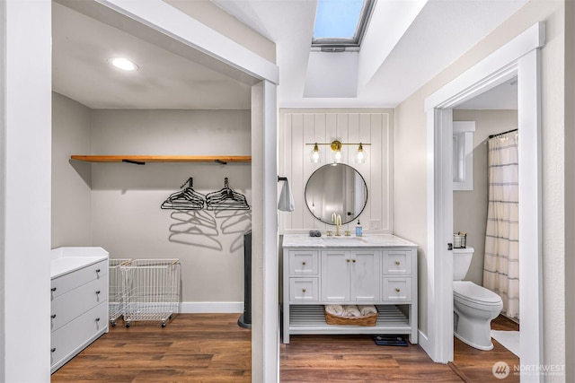 321 Park Pl, Lynden, WA 98264 - bathroom with wood finished floors, toilet, vanity, baseboards, and recessed lighting