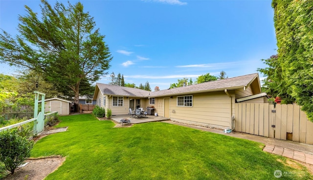 321 Park Pl, Lynden, WA 98264 - back of house featuring a patio area, a shed, an outdoor structure, a chimney, and a gate