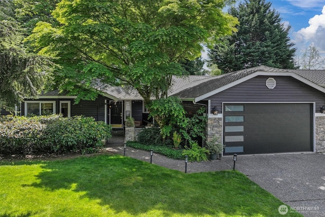 view of front facade featuring an attached garage, a front lawn, asphalt driveway, and stone siding