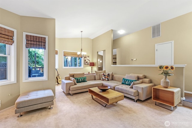 carpeted living area featuring a chandelier, lofted ceiling, and baseboards