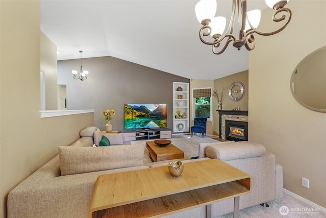 living area featuring a chandelier, vaulted ceiling, a glass covered fireplace, carpet flooring, and baseboards