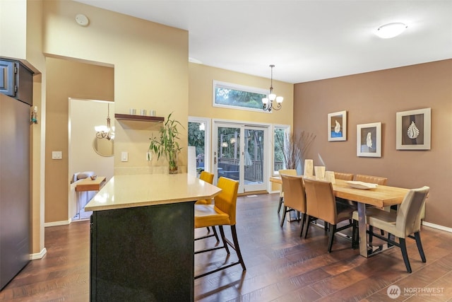 dining area with baseboards, dark wood-style flooring, and a chandelier