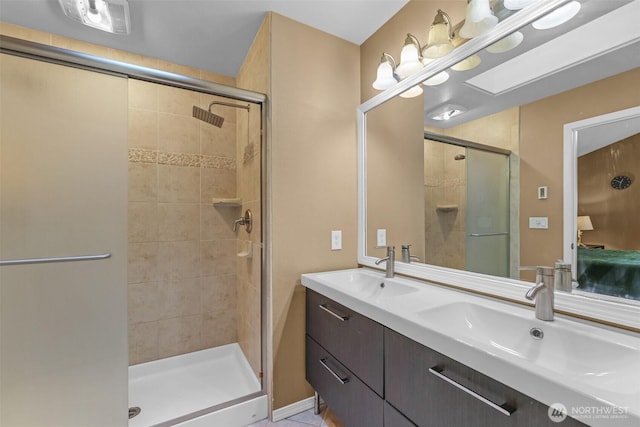 ensuite bathroom featuring a shower stall and double vanity