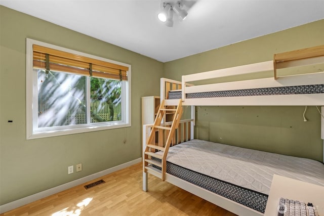 bedroom featuring wood finished floors and baseboards