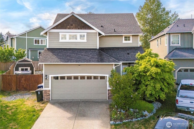 1339 E 51st St, Tacoma, WA 98404 - craftsman-style house with a shingled roof, driveway, stone siding, fence, and a garage