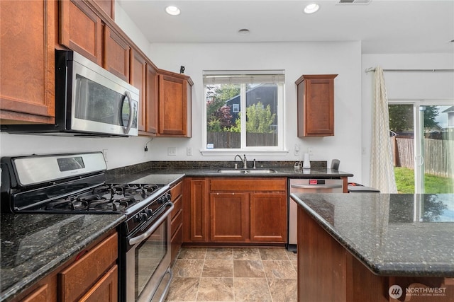 1339 E 51st St, Tacoma, WA 98404 - kitchen featuring appliances with stainless steel finishes, a sink, dark stone countertops, recessed lighting, and brown cabinets