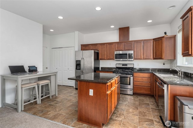 1339 E 51st St, Tacoma, WA 98404 - kitchen with stainless steel appliances, a sink, a kitchen island, dark stone countertops, and stone finish flooring