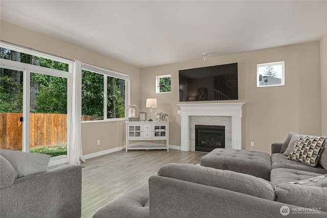 3677 SE Chesterton Dr, Port Orchard, WA 98366 - living area with healthy amount of natural light, wood finished floors, a fireplace, and baseboards