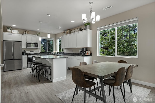 3677 SE Chesterton Dr, Port Orchard, WA 98366 - dining room featuring healthy amount of natural light, light wood-style flooring, a chandelier, recessed lighting, and baseboards