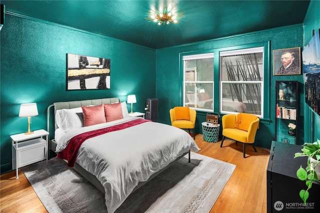 905 NE 43rd Ave Unit 110, Seattle, WA 98105 - bedroom featuring radiator, wood finished floors, and a textured wall