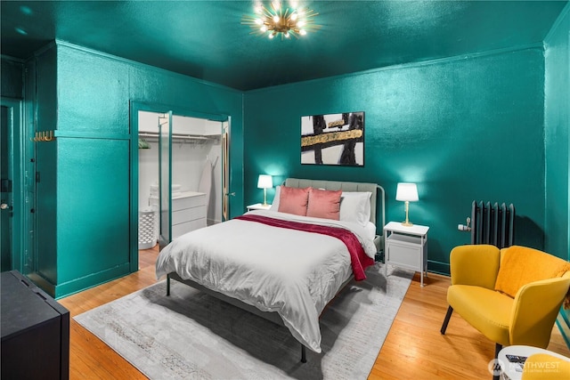 905 NE 43rd Ave Unit 110, Seattle, WA 98105 - bedroom featuring radiator, a closet, and wood finished floors