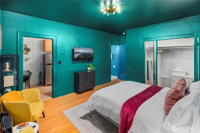 905 NE 43rd Ave Unit 110, Seattle, WA 98105 - bedroom with a closet, wood finished floors, freestanding refrigerator, and a textured wall