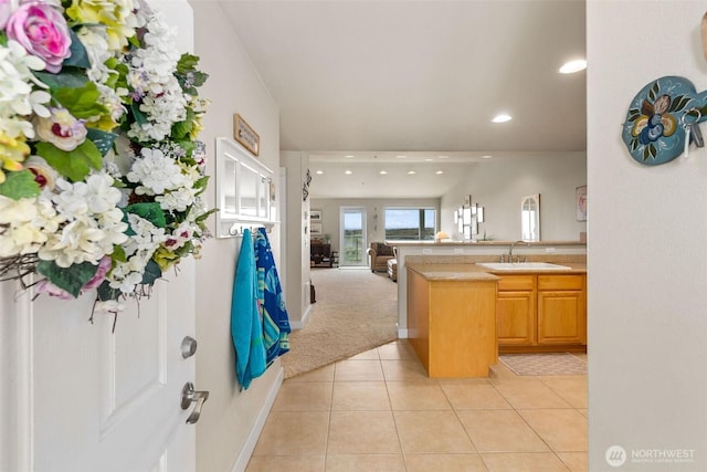 kitchen featuring a sink, open floor plan, recessed lighting, light tile patterned flooring, and a peninsula