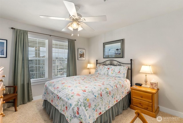 bedroom featuring light colored carpet, baseboards, and a ceiling fan