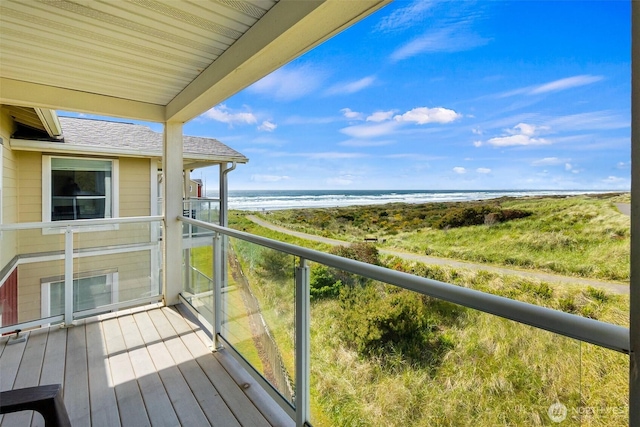 balcony with view of water and beach