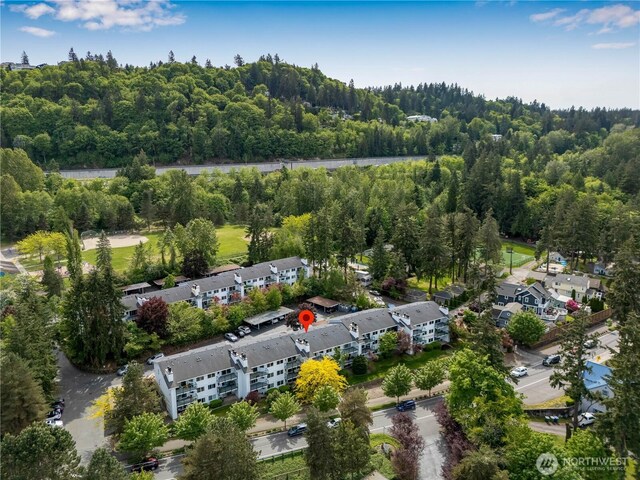 aerial view of property's location featuring a forest