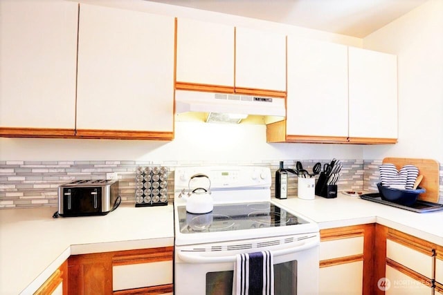 1515 Ocean Beach Blvd Unit 202, Long Beach, WA 98631 - kitchen with electric range, under cabinet range hood, light countertops, and decorative backsplash
