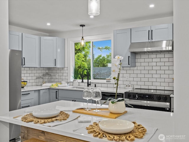 kitchen with under cabinet range hood, electric range, gray cabinets, a sink, and light countertops