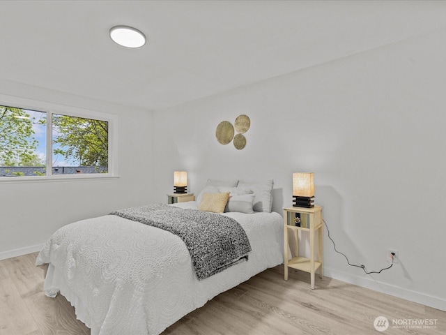 bedroom with light wood-style flooring and baseboards