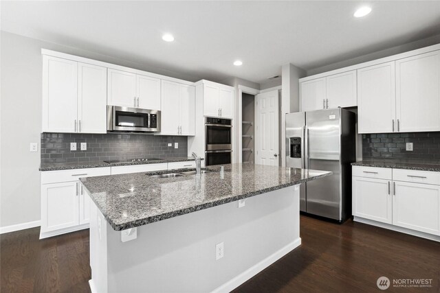 4933 Wanderlust Way, Gig Harbor, WA 98332 - kitchen featuring stainless steel appliances, a sink, dark wood finished floors, dark stone counters, and recessed lighting