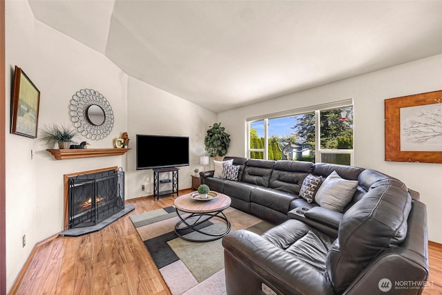 8224 Quinault Rd, Blaine, WA 98230 - living room with wood finished floors, lofted ceiling, a lit fireplace, and baseboards