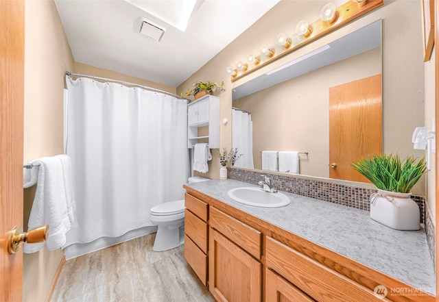8224 Quinault Rd, Blaine, WA 98230 - full bath featuring vanity, toilet, wood finished floors, and tasteful backsplash
