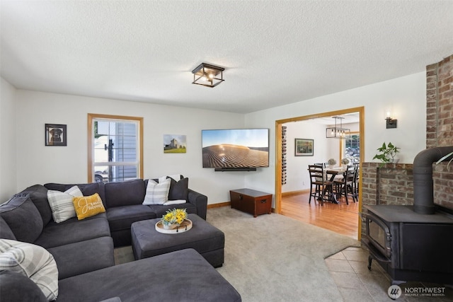 15513 NE Beebe Rd, Battle Ground, WA 98604 - carpeted living area featuring a wood stove, a textured ceiling, a chandelier, and baseboards