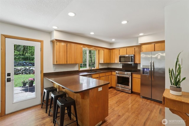 15513 NE Beebe Rd, Battle Ground, WA 98604 - kitchen with appliances with stainless steel finishes, dark countertops, a peninsula, a sink, and recessed lighting