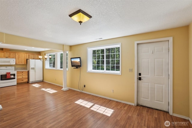15513 NE Beebe Rd, Battle Ground, WA 98604 - unfurnished living room featuring light wood-style floors, plenty of natural light, baseboards, and a textured ceiling