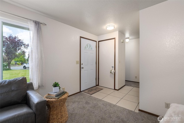 entrance foyer with light carpet and light tile patterned floors