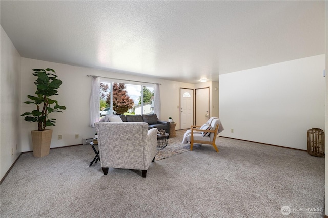 living area with light colored carpet, baseboard heating, baseboards, and a textured ceiling