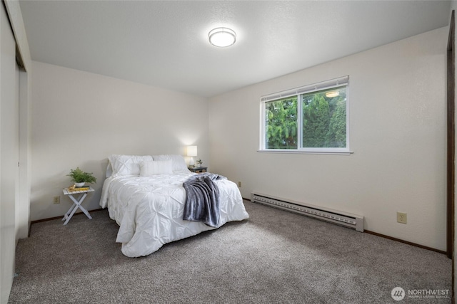 bedroom featuring a baseboard heating unit, carpet flooring, and baseboards