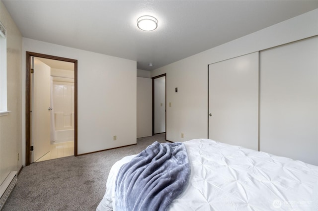 carpeted bedroom with baseboard heating, connected bathroom, and a closet