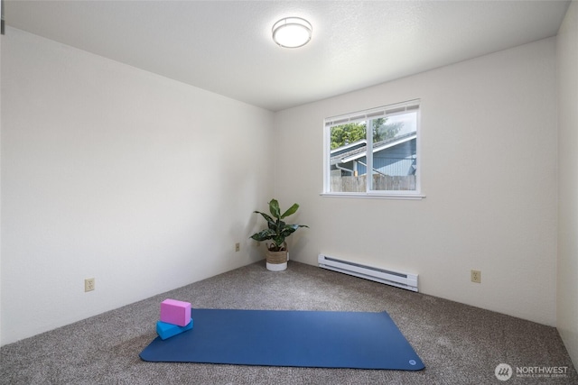 exercise area featuring a baseboard heating unit and carpet flooring