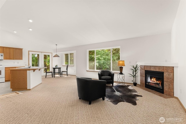 13008 65th Avenue Ct SW, Lakewood, WA 98499 - living area featuring light colored carpet, healthy amount of natural light, a tile fireplace, lofted ceiling, and french doors